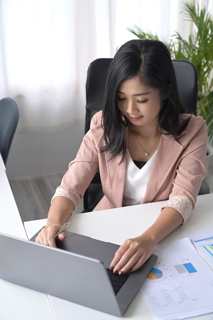 Bovenaanzicht Aziatische vrouw kantoormedewerker met behulp van computer laptop op haar werkplek