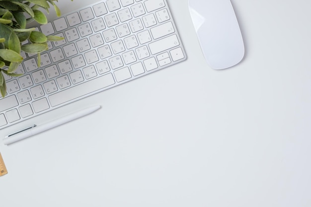 Bovenaanzicht bureau met toetsenbordmuis en notebook op witte tafel backgorund