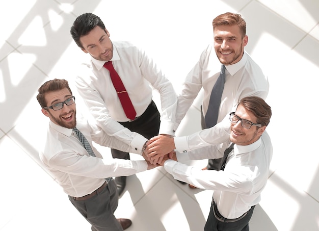 Bovenaanzicht business team dat hun handen in elkaar steekthet concept van teamwork
