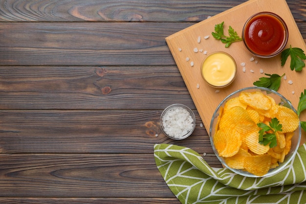 Bovenaanzicht chips met saus in kom op gekleurde achtergrond bovenaanzicht met kopieerruimte