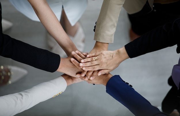 Bovenaanzicht close-up shot van professionele succesvolle groep zakenman zakenvrouw collega's partnerschap team handen bij elkaar te houden voor bedrijf sterk vertrouwen teamwerk eenheid prestatie inzet.