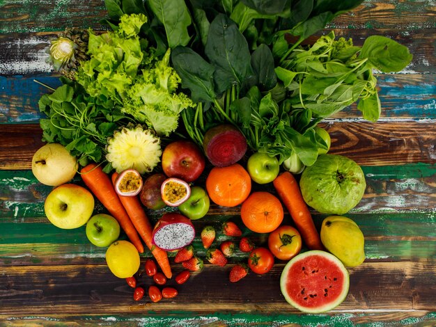 Foto bovenaanzicht close-up shot van verschillende soorten gezonde smakelijke voedzame verse rauwe natuurlijke biologische landbouw veganistische groenten en fruit ingrediënt dieet geplaatst op oude kleurrijke houten tafel achtergrond.