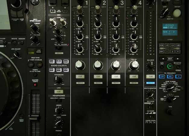 Bovenaanzicht close-up van dj muzikale mixer professionele console zwarte kleur met veel knoppen en knoppen in nachtclub of studio op digitale achtergrond, horizontale afbeelding.