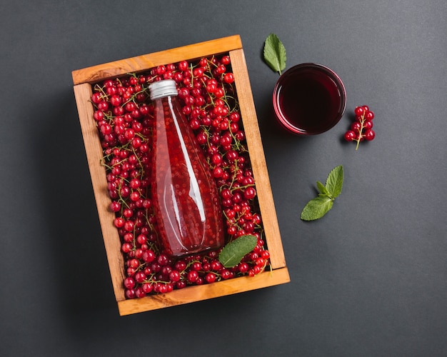 Bovenaanzicht cranberry sap fles in houten kist