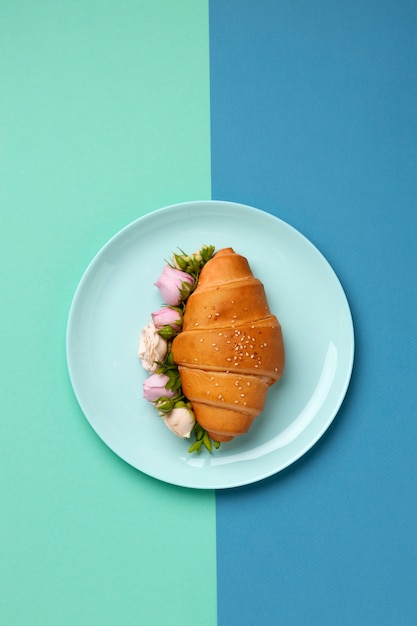 Foto bovenaanzicht croissant met bloemen op bord