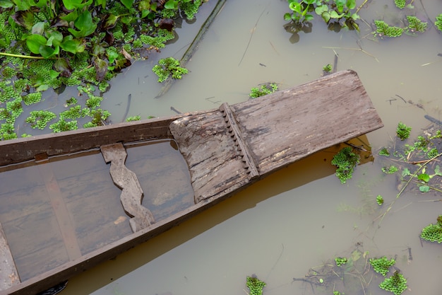 Foto bovenaanzicht de boeg van houten boot terwijl deze op het kanaal drijft