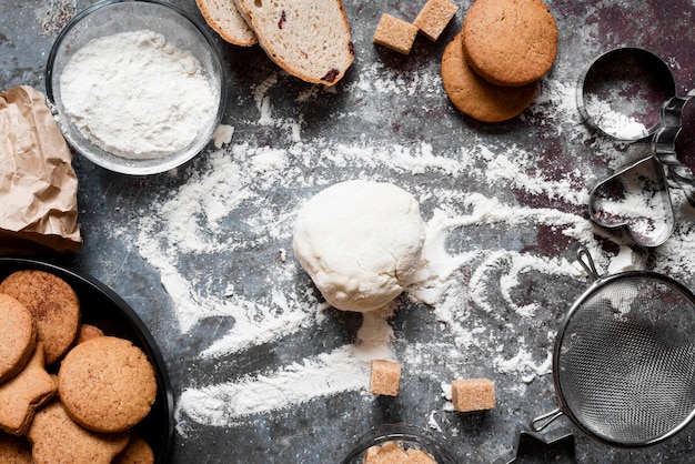 Foto bovenaanzicht deeg op teller met bloem en koekjes