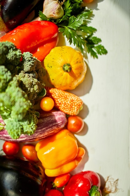 Bovenaanzicht diverse verse biologische groenten op tafel in de keuken in zonlicht kruidenierswinkel gezond winkelen veganistisch foodb plat lag kopieerruimte Lay-out met vrije tekst