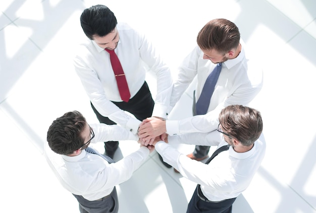 Bovenaanzicht een groep medewerkers vouwde hun handen samenhet concept van teamwork