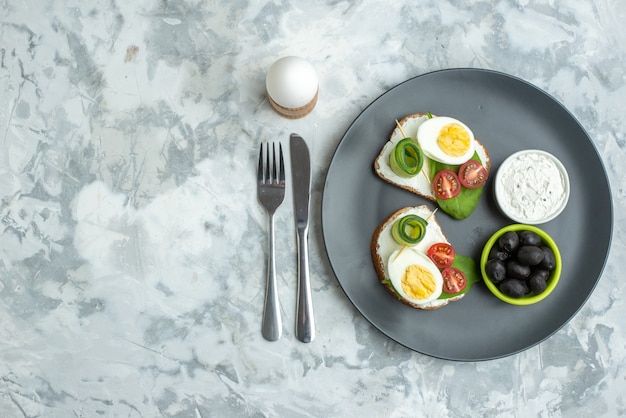 Bovenaanzicht ei sandwiches met mes en vork binnen plaat witte achtergrond sandwich dieet gezondheid hamburger brood maaltijd lunch eten toast vrije ruimte