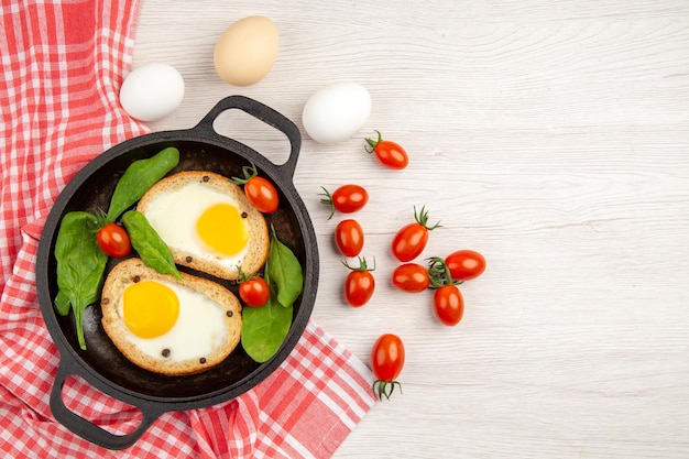 Bovenaanzicht ei toast in pan met tomaten en verse eieren op witte achtergrond brood kleur lunch schotel ontbijt maaltijd thee eten