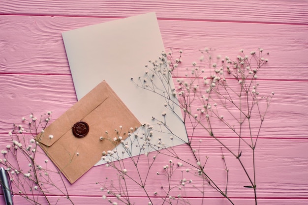 Bovenaanzicht envelop met blanco papier en lentebloemen