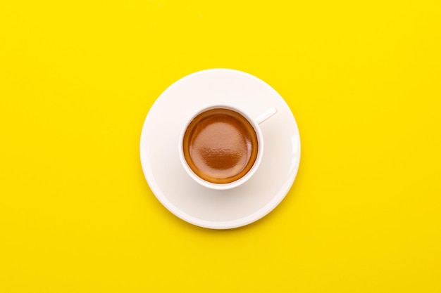 Bovenaanzicht espressokoffie in witte kop op yellowxA