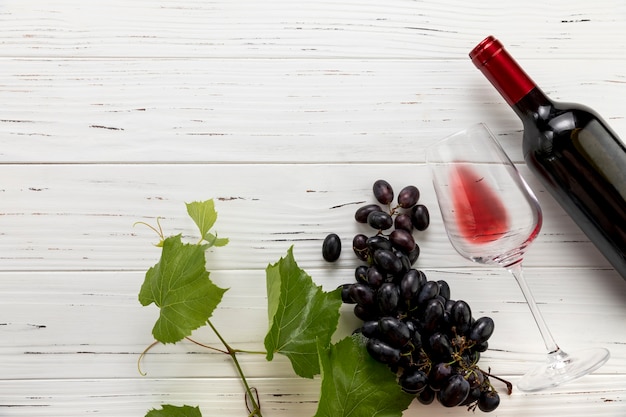 Foto bovenaanzicht fles wijn met glas en een tros druiven