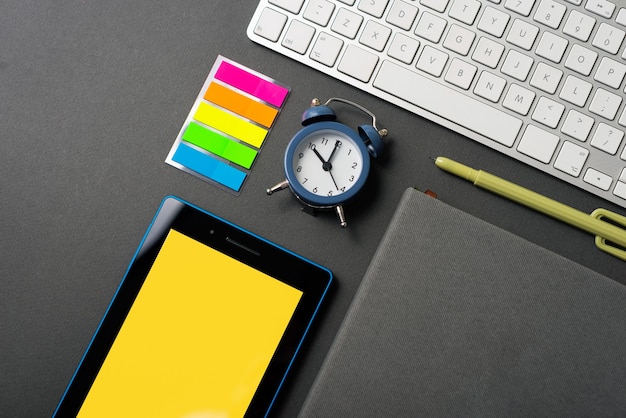 Bovenaanzicht foto van bureau met tablet toetsenbord planner agenda wekker