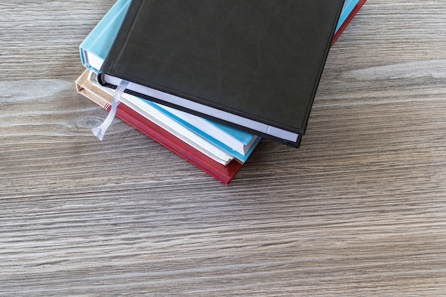 Bovenaanzicht foto van stapel boeken op geïsoleerde houten tafel achtergrond