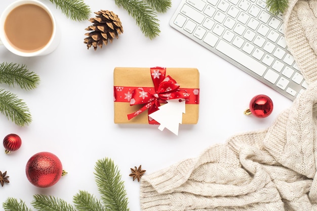 Bovenaanzicht foto van toetsenbord kopje warm drinken rode kerstboom ballen pine twijgen kegel anijs gezellige trui en geschenkdoos met spar vormige tag op geïsoleerde witte achtergrond