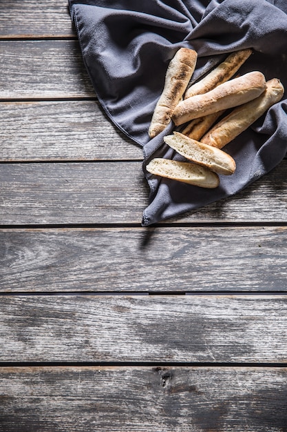 Bovenaanzicht Franse mini stokbrood op tafelkleed en houten tafel.