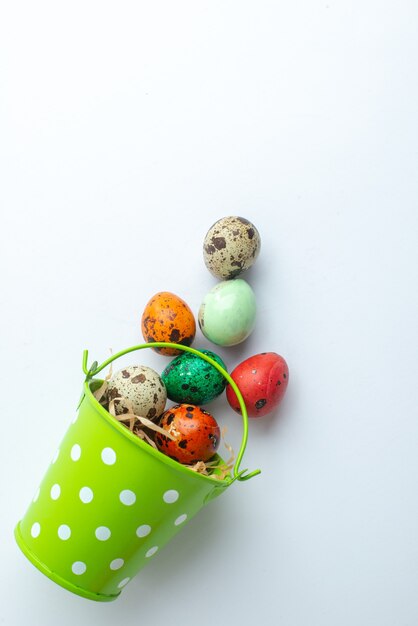bovenaanzicht gekleurde beschilderde eieren in groene mand op witte achtergrond sierlijke lente kleurrijke concept vakantie novruz horizontal