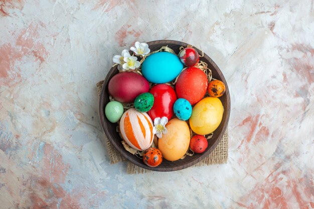 Bovenaanzicht gekleurde beschilderde eieren in plaat op witte achtergrond suiker kleurrijke sierlijke novruz zoete vakantie dessert