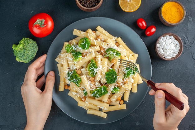 Bovenaanzicht gekookte pasta met broccoli op grijze achtergrond peper kleur voedsel maaltijd italië deeg groene salade foto