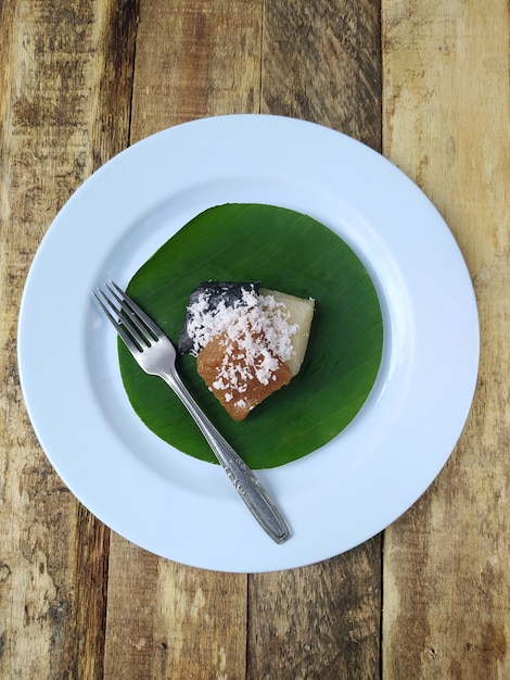 Bovenaanzicht getuk of eten van cassave en kokosnoot op een bord en bananenblad met houten tafel, traditioneel eten uit Indonesisch Java