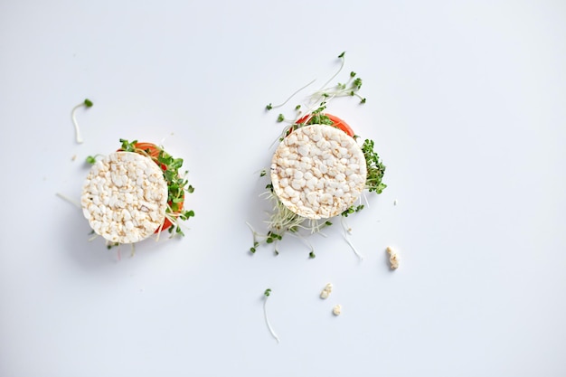 Bovenaanzicht Gezonde burger met krokant rijstbrood groenten tomaat en microgreens