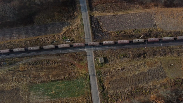 Bovenaanzicht goederentrein passeren spoorwegovergang luchtfoto drone uitzicht vlucht over