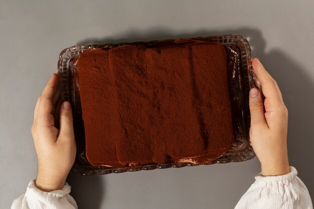 Bovenaanzicht handen met tiramisu dienblad