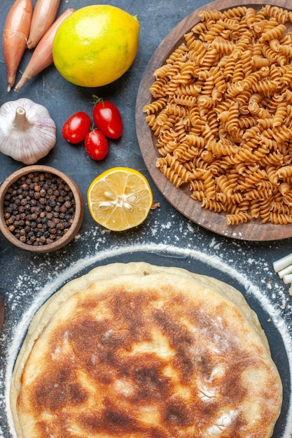 Bovenaanzicht heerlijke flapjacks met verschillende ingrediënten kruiderijen en pasta op donkere achtergrond maaltijd brood kleur notenbroodje schotel