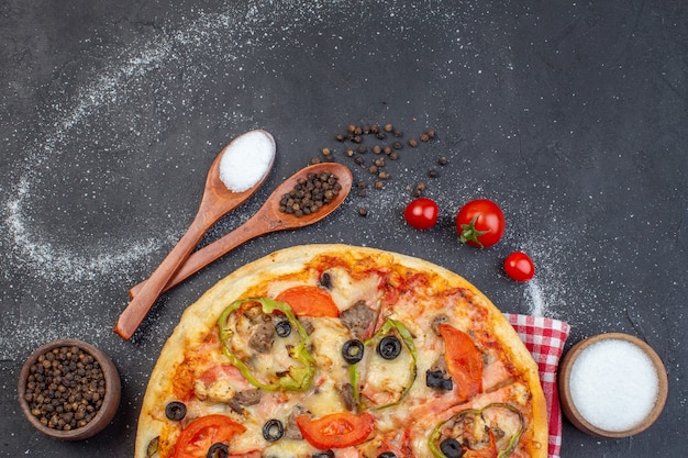 Bovenaanzicht heerlijke kaas pizza met rode tomaten op donkere ondergrond