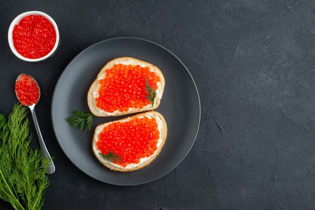 Bovenaanzicht heerlijke kaviaar sandwiches in plaat op donkere ondergrond