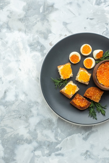 bovenaanzicht heerlijke kaviaar sandwiches met gekookte eieren binnen plaat witte achtergrond ontbijt eten maaltijd zeevruchten vis lunch brood