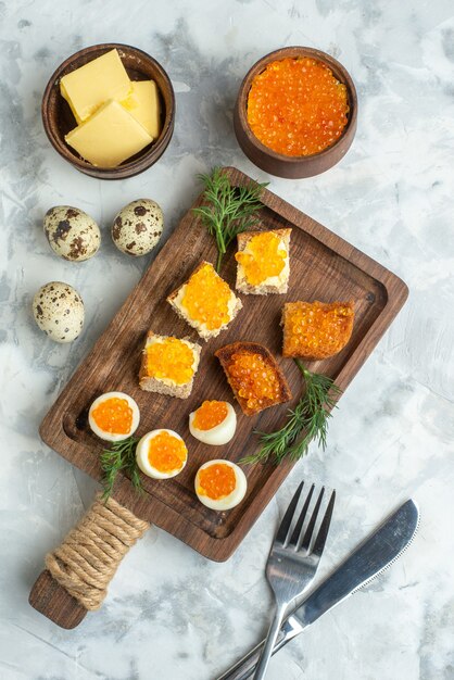 Bovenaanzicht heerlijke kaviaar sandwiches met gekookte eieren op snijplank wit oppervlak ontbijt vis zeevruchten lunch eten toast maaltijd