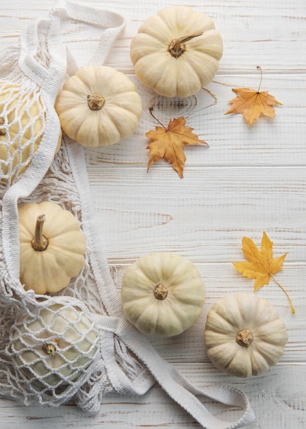 Bovenaanzicht herfst samenstelling met pompoenen in mesh boodschappentas