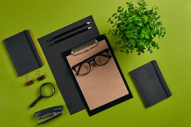 Bovenaanzicht in focus met verschillende kantoorapparatuur levert briefpapier groene achtergrond met kopie spa