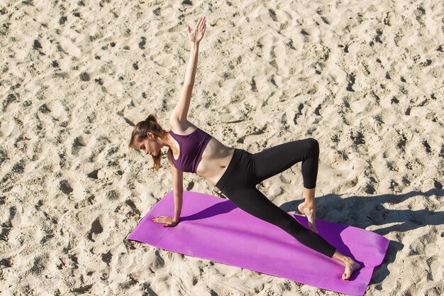 Bovenaanzicht. Jonge vrouwelijke atleet, vrouw training, buiten oefenen in de herfstzon. Mooie blanke sportvrouw die in de open lucht traint. Concept van sport, gezonde levensstijl, beweging, activiteit.