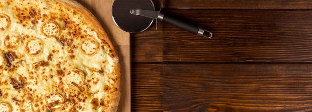 Bovenaanzicht kaas pizza op snijplank met kopie-ruimte