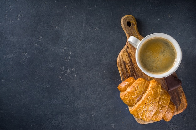 Bovenaanzicht koffie en croissant op tafel