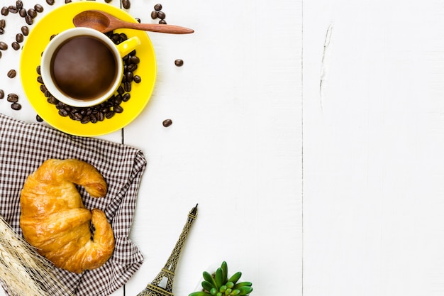 bovenaanzicht koffie en een croissant met koffieboon