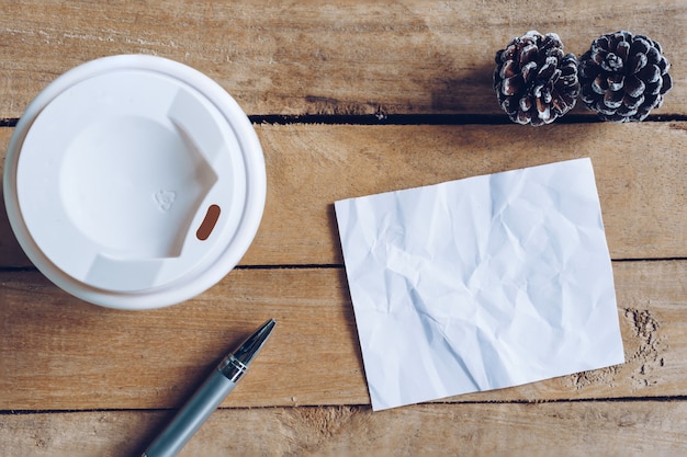 Bovenaanzicht koffiekopje en pen, blanco papier op hout met Kerstdecoratie f