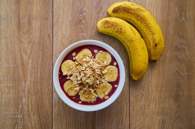 Bovenaanzicht kom met bananen en muesli.