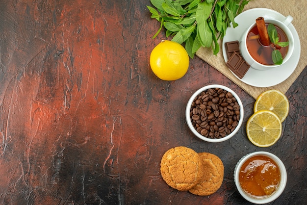 bovenaanzicht kopje koffie met koekjes en thee op donkere achtergrond suiker koekje kleur ochtend ontbijt cacao zoete thee vrije ruimte