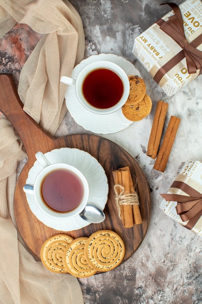 Bovenaanzicht kopjes thee met zoete koekjes en cadeautjes op lichte achtergrond pauze suiker taart ceremonie taart kleur koffie