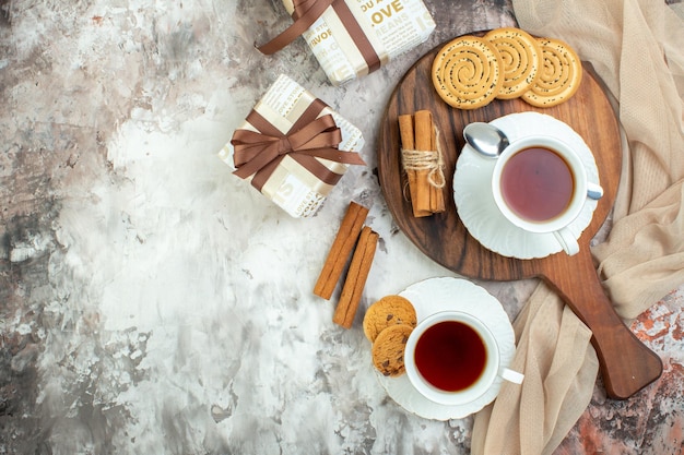 Bovenaanzicht kopjes thee met zoete koekjes en koekjes op lichte achtergrond pauze suiker taart ceremonie taart kleur koffie vrije ruimte