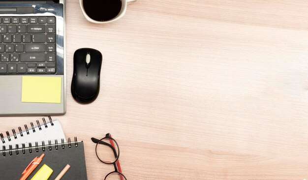 Bovenaanzicht laptop en accessoires op houten tafel met kopieerruimte