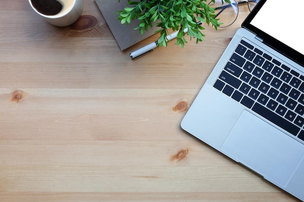 Bovenaanzicht laptopcomputer boeken potplant en koffiekopje op houten tafel