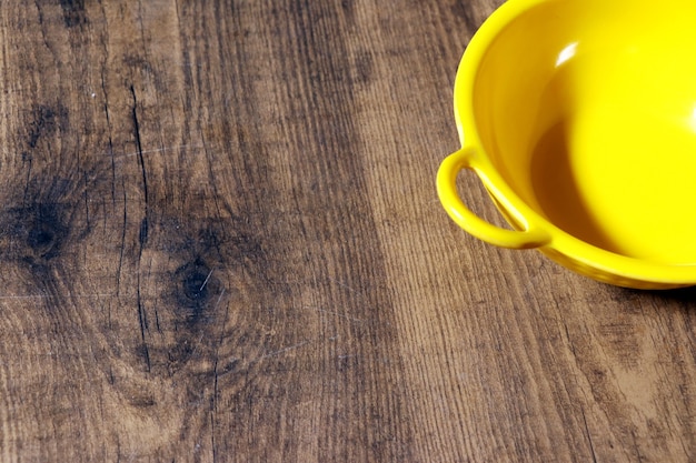 Bovenaanzicht lege gele kom op rustieke houten tafel