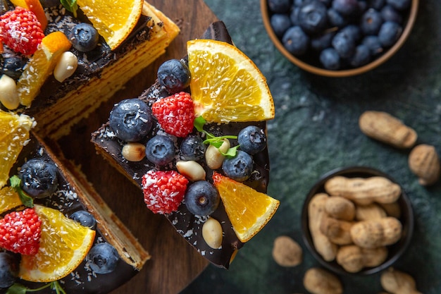 Bovenaanzicht lekkere chocoladetaart met fruit op donker