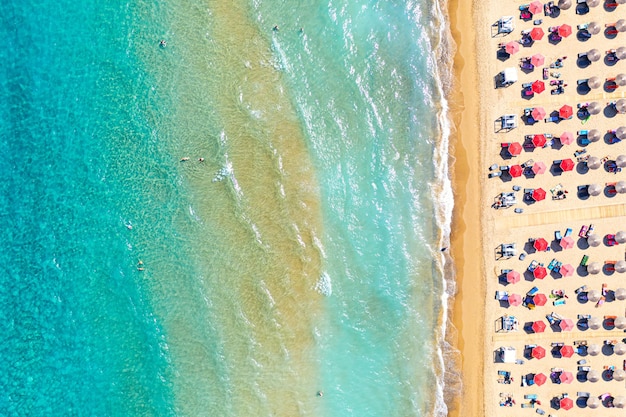 Bovenaanzicht luchtfoto drone foto van banaan strand met prachtige turquoise water zee golven en rode parasols vakantie reizen achtergrond Ionische zee Zakynthos eiland Griekenland